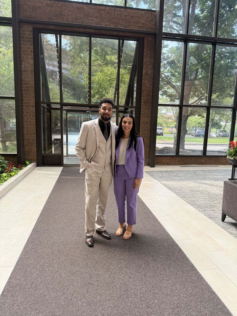 Two professionally dressed team members outside an office building