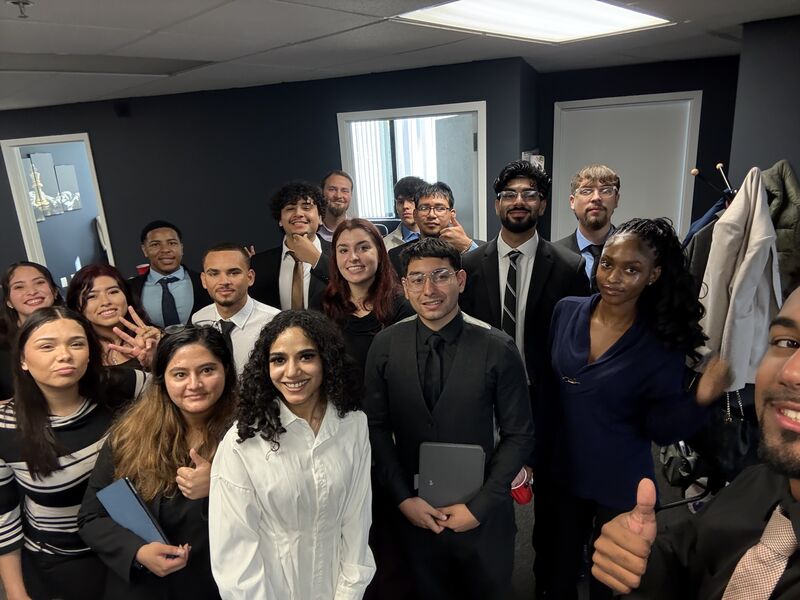 A large, smiling team gathered together inside the Consistency Collective office